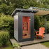 Portable sauna on a wooden deck with an orange chair and greenery