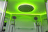 Shower cabin with green LED lighting and multiple shower heads.