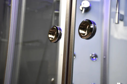 Close-up of a shower enclosure with gold knobs and control panel.