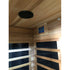 Wooden sauna with black mesh panels and a ceiling light fixture.