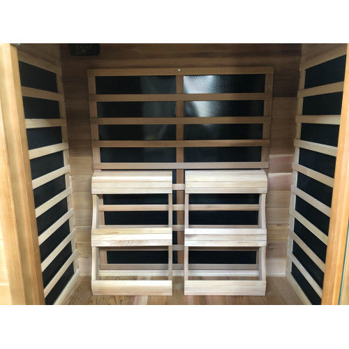 Infrared sauna with wooden benches and black panels on the walls.