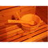 Wooden sauna bucket and ladle on a wooden bench inside a sauna.